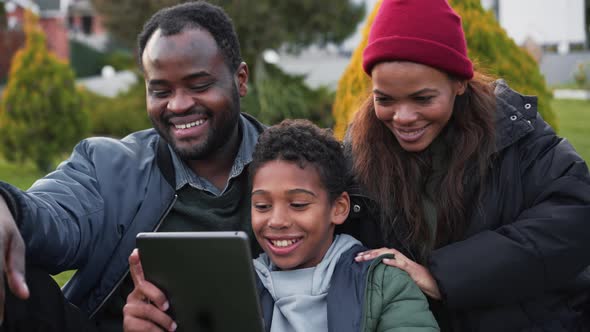 Positive African family making selfie on the tablet