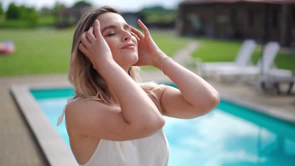 Portrait of Satisfied Beautiful Woman Standing at Poolside Enjoying Leisure and Looking at Camera