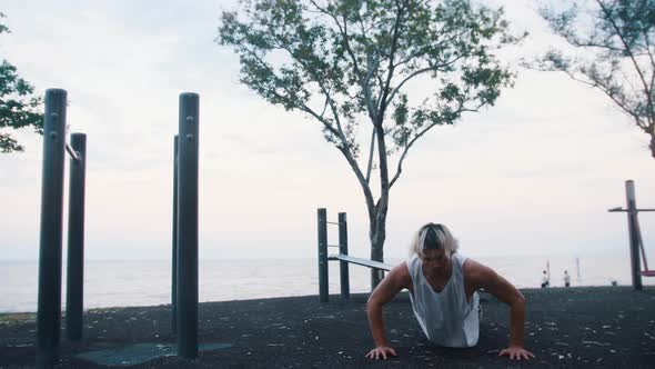 A Man Does Pushups and Jumping on the Spot on the Sports Playground