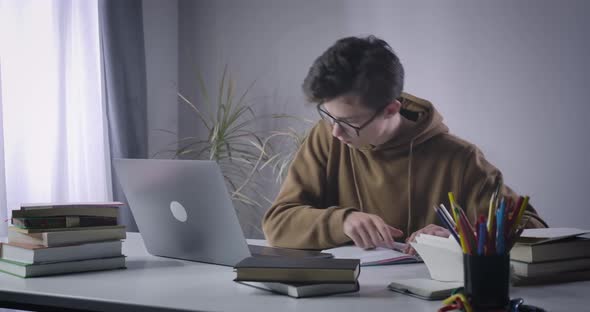 Excited Caucasian Nerd Boy Typing Fast on Laptop Keyboard. Absorbed College Student Searching alt