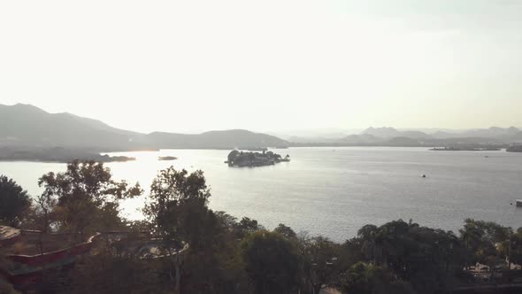 view from the shore of Taj Lake Palace in Lake Pichola in the late evening mist, in Udaipur, India