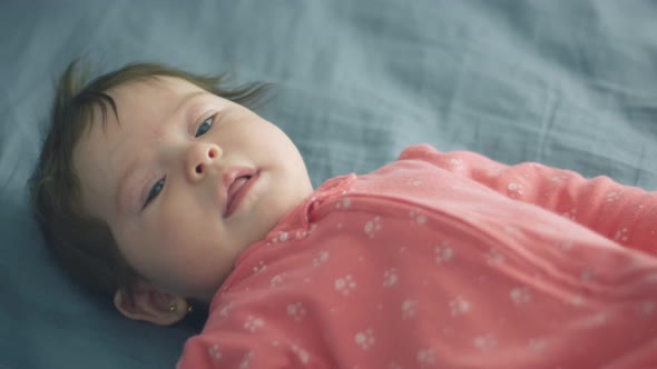 Slow Motion of Beautiful Baby Lying Down and Moving in Bed