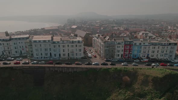 Aerial view panning across colourful seafront hotels overlooking Scarborough North Bay coastal seasi