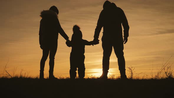 Silhouette Happy Child with Mother and Father Family at Sunset