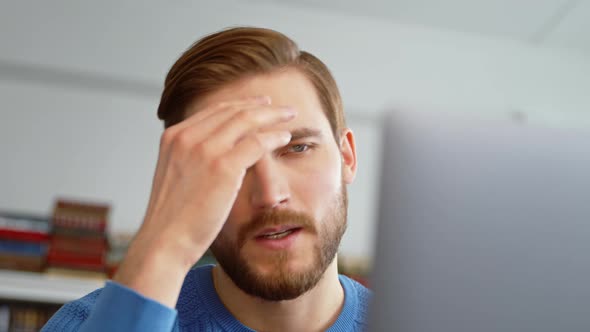 Tired young male surfing the internet using a laptop