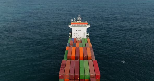 Container ship loaded with Shipping containers holding position at sea.