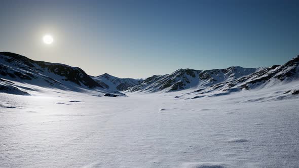 Aerial Landscape of Snowy Mountains and Icy Shores in Antarctica alt