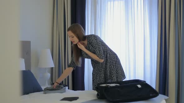 Female Check Weather Outside and Packing a Suitcase in Hotel