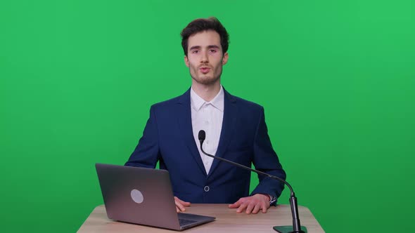 Portrait of Lecturer in a Suit Standing on a Green Background the Man Speaks to the Audience and