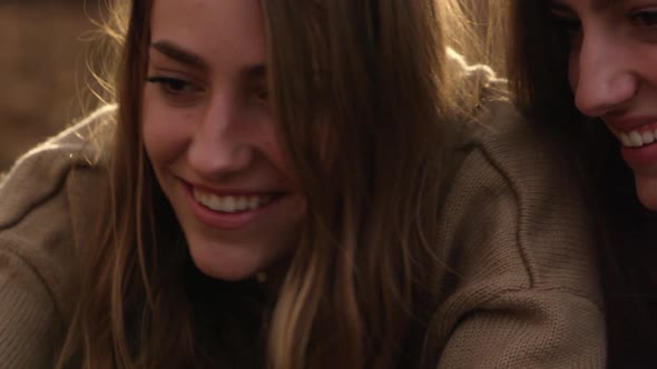 Teenage girls smiling at smartphone posing for photo