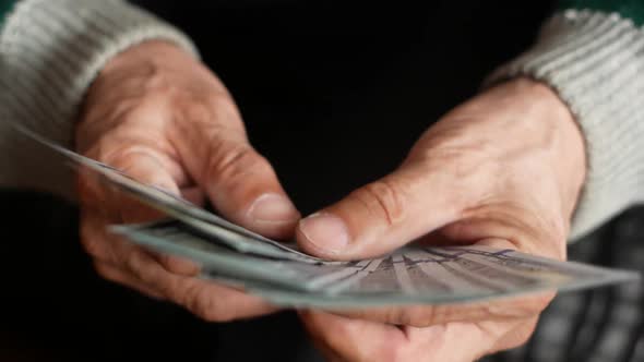 Close-up of male hands holding a fan of American dollar bills