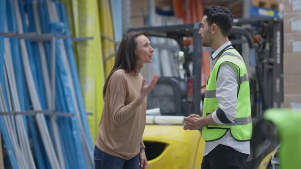 Anxious Nervous Man and Woman Arguing in Industrial Warehouse Yelling and Gesturing