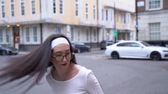 Young woman turns, hair flips, smiles, Soho, London, close up slow motion