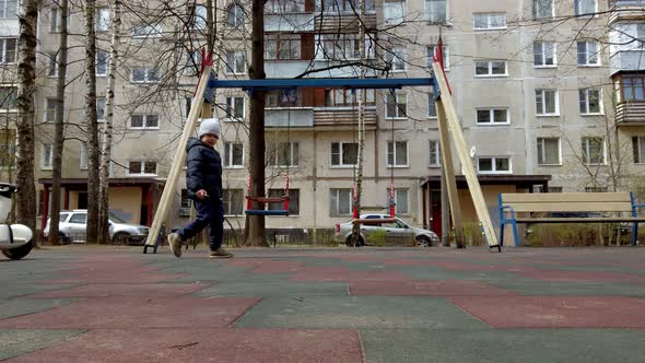 Little Boy Funny Playing on the Playground with the Help of New Technology Segway Gadget in Early