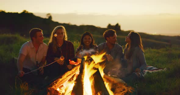 Friends Relaxing at Sunset Campfire