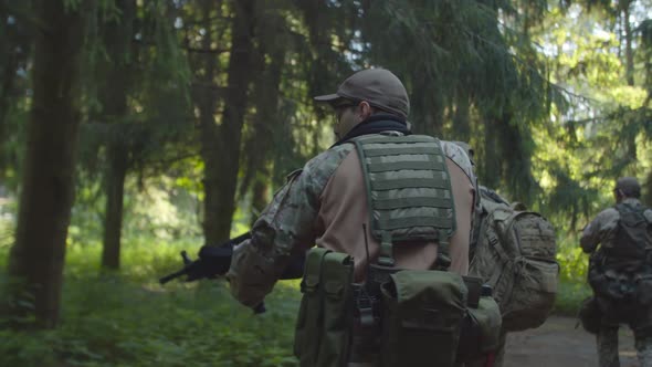 Rearguard Soldier with Machine Gun Covering Back of Squad in Forest alt