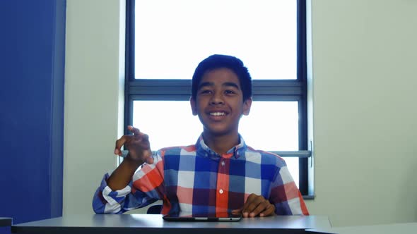 Schoolboy pretending to using invisible futuristic screen in classroom