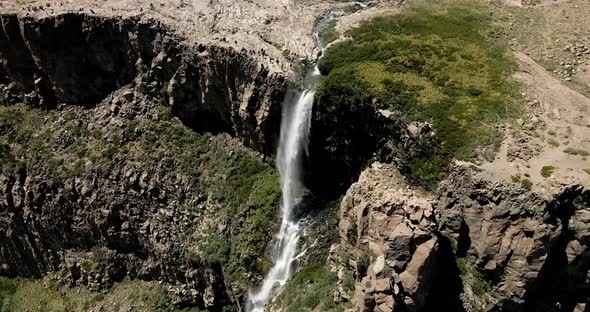 Aerial view of the inverted waterfall with a rainbow running completely through it while the water i