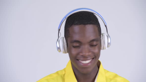 Face of Young Happy African Businessman Listening To Music