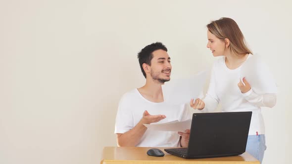 Unhappy Couple with Bills and Laptop at Home, Paying Taxes