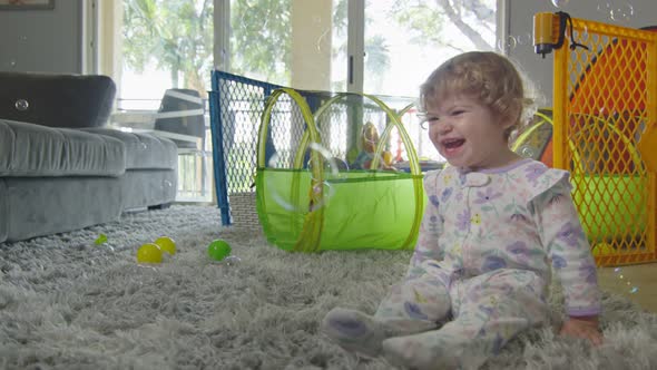 Slow Motion of Baby Girl Laughing and Kicking, Playing with Bubbles