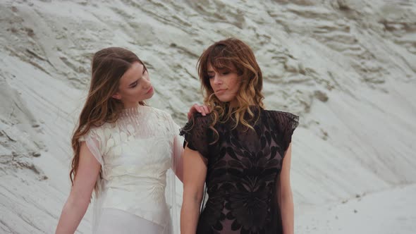 Portrait of Caucasian Beautiful Young Females in White and Black Dresses Back To Back and Smiling 