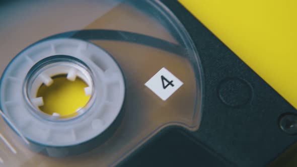 Old Compact Cassette with Number Four on Yellow Background