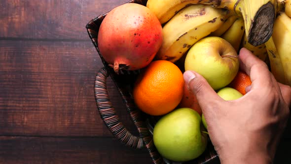 Man's Hand Picking Apple From a Bowl 