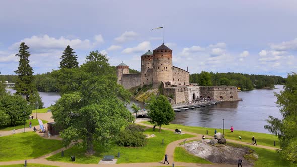 Flying Drone Dolly Shot Approaching Medieval Castle Olavinlinna (Finland) on a Summer Day in Savonli