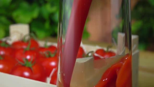 Tomato Juice Is Poured in a Glass Jug Next To the Wooden Box Full of Tomatoes