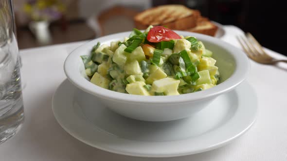 Salad of wild garlic, cucumber, boiled egg and sour cream rotates