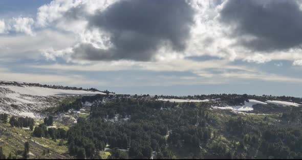 Time Lapse of Cloudscape Behind of the Mountains Top. Snow, Rocks, Cliffs and Deep Blue Sky. High