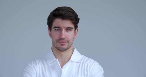 Portrait of Handsome Doctor or Scientist Wearing a White Coat Looking at Camera Isolated on White