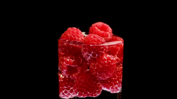 Ripe Red Raspberries in Water Glass Rotate Isolated Black Background