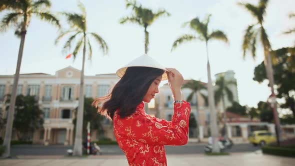 Vietnamese Girl Puts on a National Cap Non La in the Rays of the Evening Sunset in Da Nang