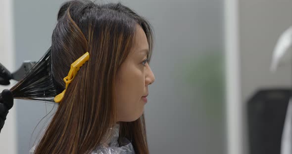 Woman have hair dye at beauty salon