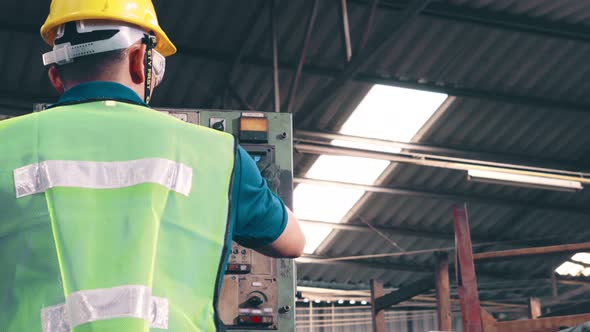 Group of Factory Workers Using Machine Equipment in Factory Workshop