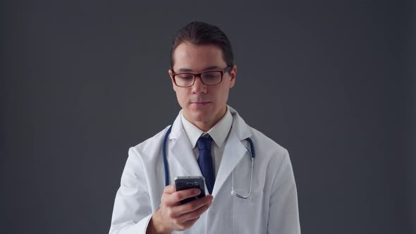 Studio portrait of young professional medical doctor standing over grey background