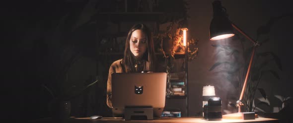 Woman examines camera while at desk