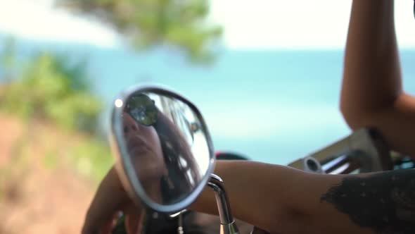 Girl with Big Tattoo Reflects in Small Motorcycle Mirror
