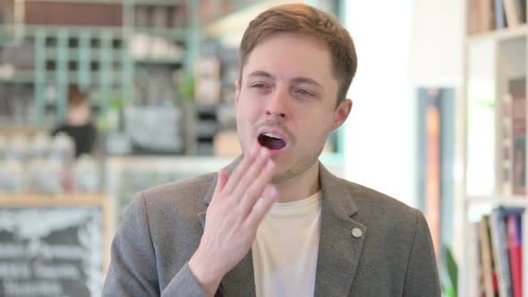 Portrait of Sleepy Young Man Yawning