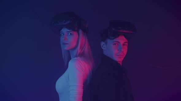 Close Up Portrait of Two Gamers Young Man and Girl Standing at the Cyber Neon Lighting Background