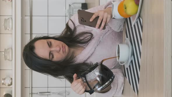 Woman Pours Coffee While Using Smartphone