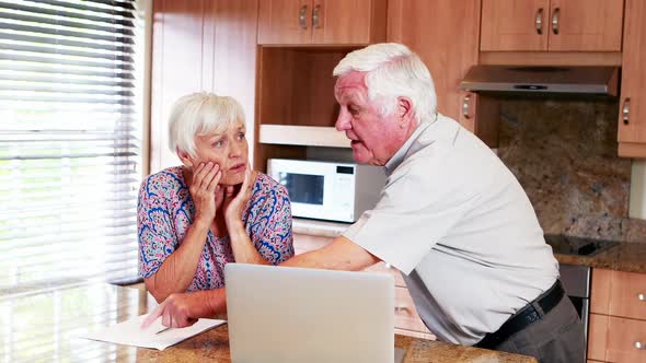 Senior couple arguing with each other in kitchen