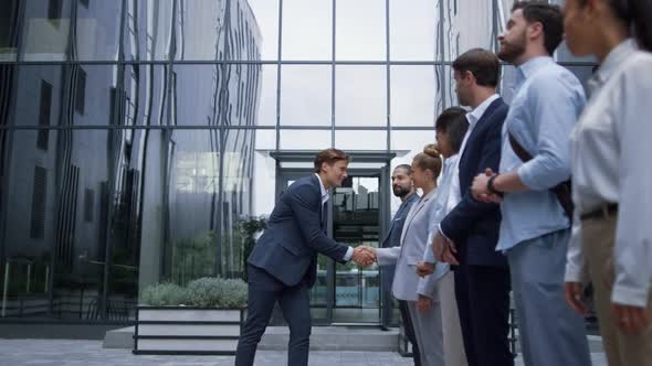 Thankful Leader Shaking Hands at Office Building