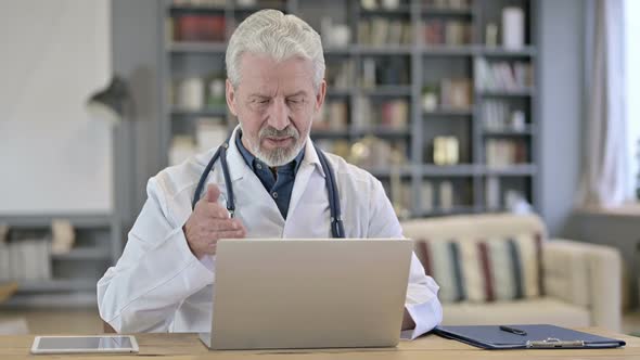 Senior Old Doctor Doing Video Chat on Laptop