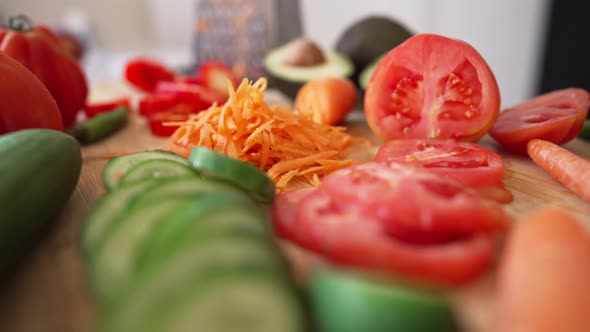 Closeup Salad Ingredients Lying on Wooden Cutting Board on Table