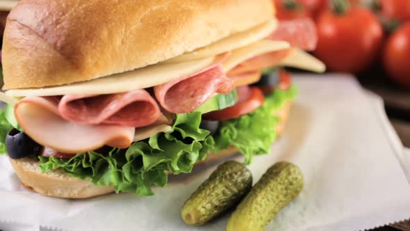 Sub sandwich with fresh vegetables, lunch meat and cheese on hoagie roll.