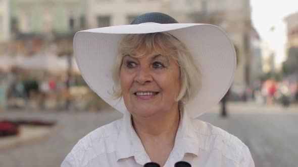 Senior Woman Tourist Exploring Town, Looking in Binoculars, Travel Lviv, Ukraine