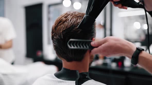 Barber Uses a Hair Dryer To Style His Hair.